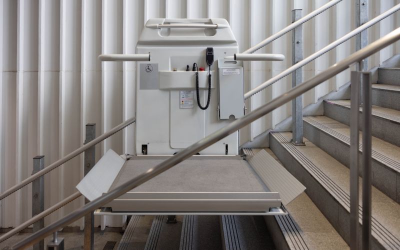 a stair lift for the disabled, wheel chair lift for stairs. Mechanical chair lift taking disabled or aged people up and down stairs.
