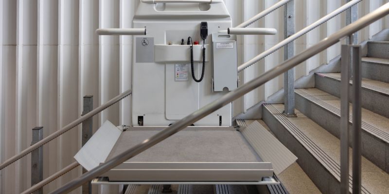 a stair lift for the disabled, wheel chair lift for stairs. Mechanical chair lift taking disabled or aged people up and down stairs.
